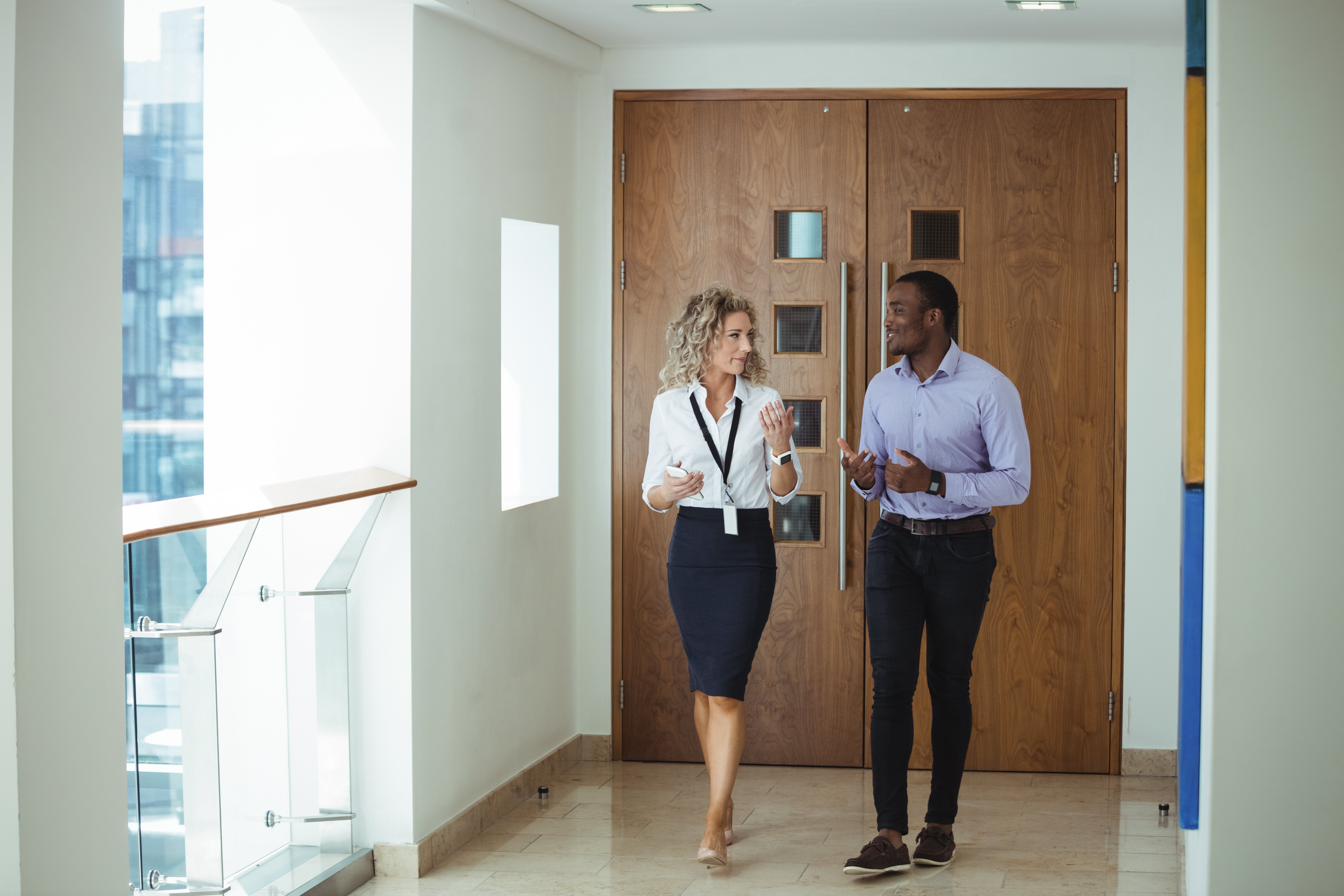 business-executives-having-discussion-while-walking-corridor
