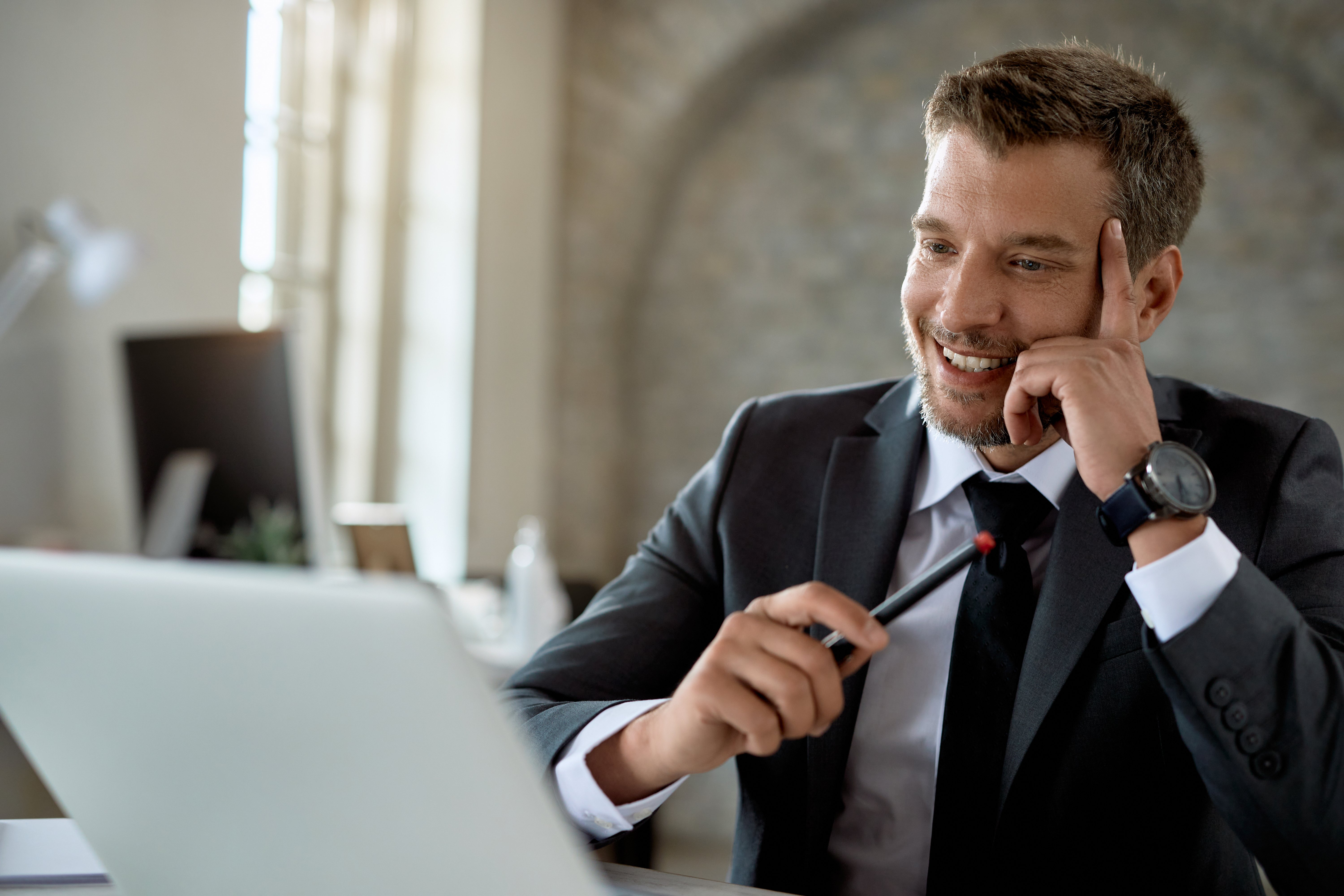 happy-mid-adult-businessman-working-computer-reading-email-office