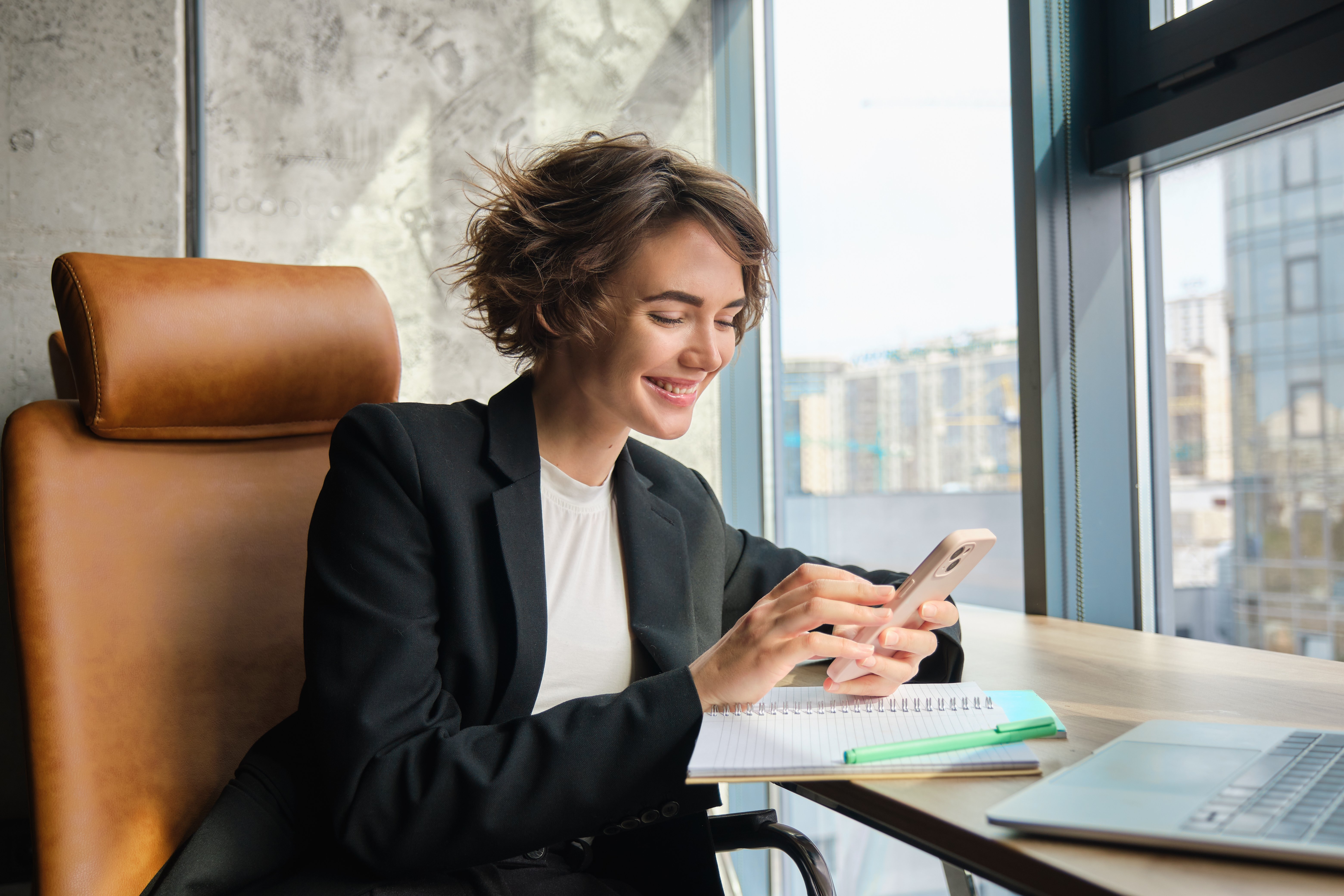portrait-corporate-woman-suit-sits-office-messaging-someone-replying-friend