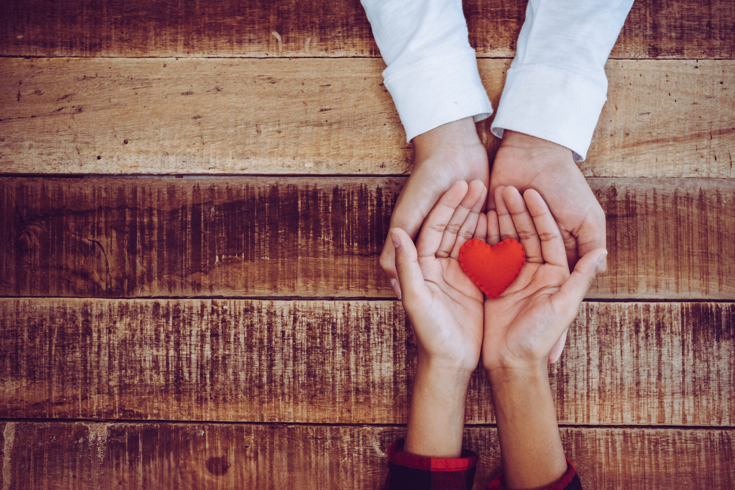 Two pairs of hands holding a red heart [Transporting Your Donor to the Scene: Zeroing In on the Need]