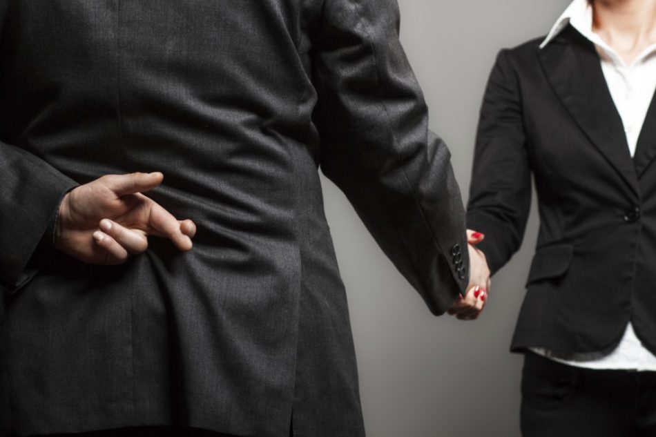 picture of businessman shaking hands with businesswoman with his fingers crossed behind his back organization