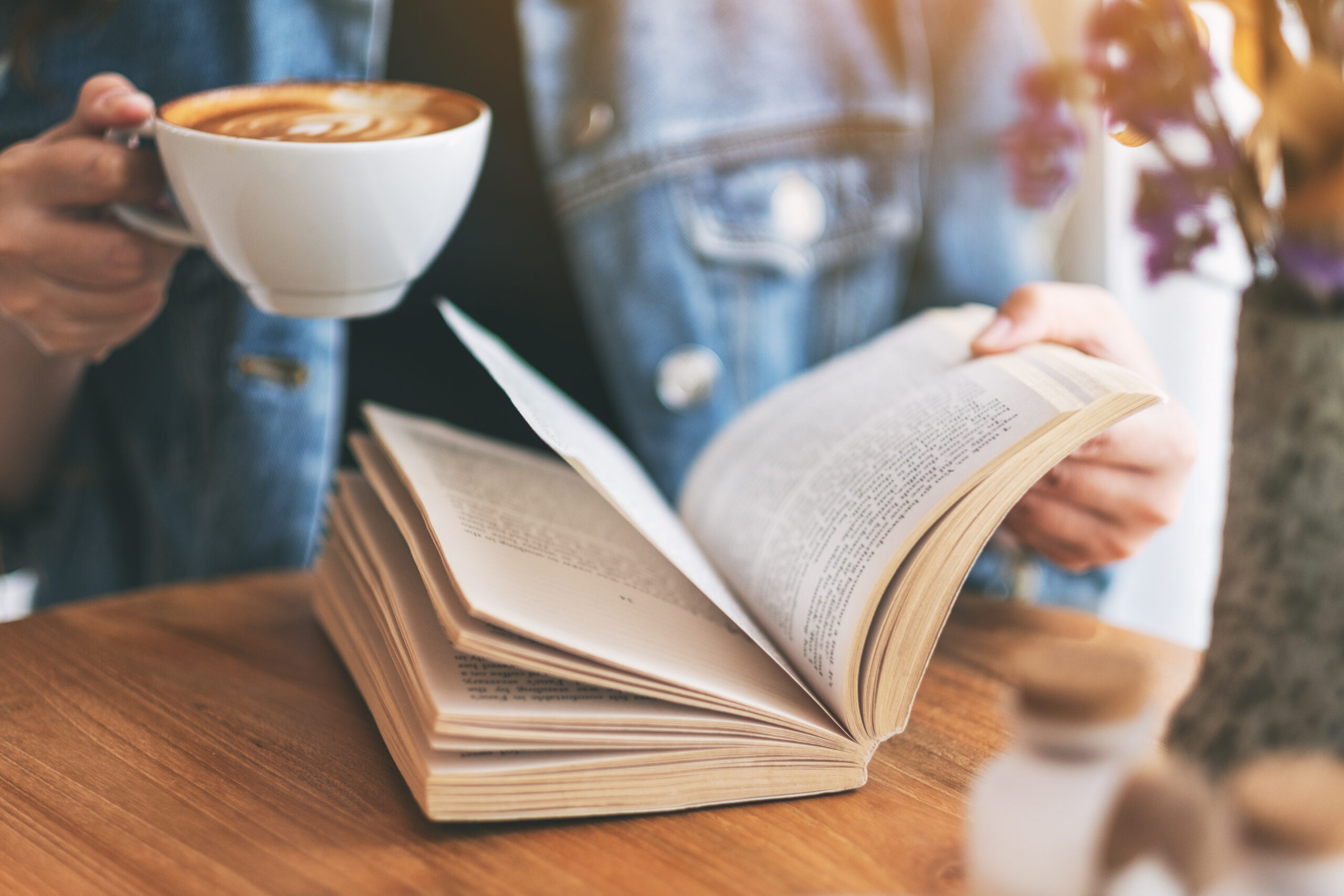 A closeup of someone reading in a coffee shop [Must-Read Books for Fundraisers: Your TBR Guide]
