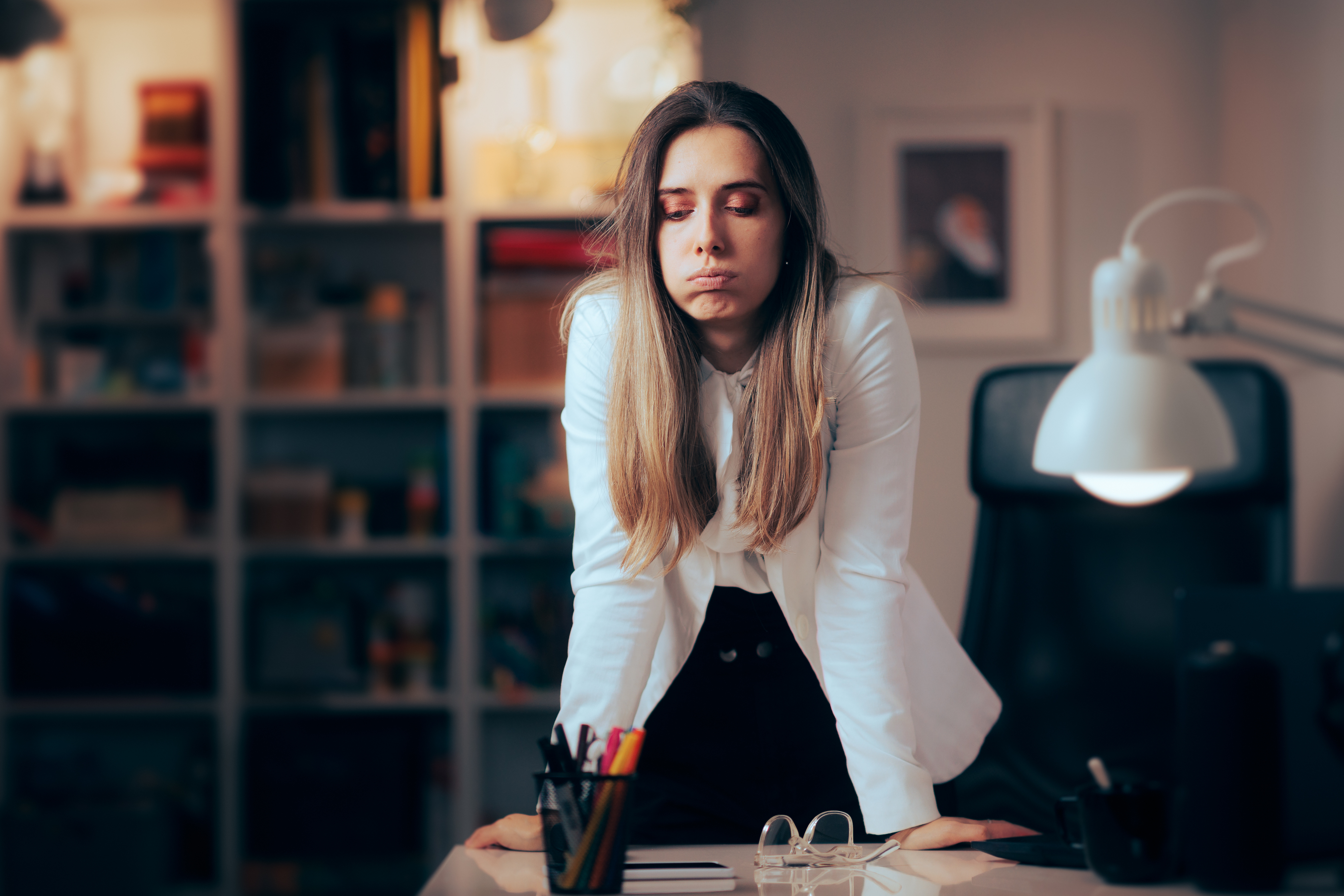 Business woman sighs in stress. [How to Manage Team Stress (When You’re Stressed Out, Too)]