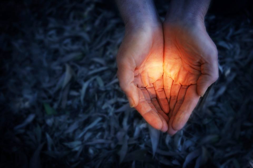 Hands holding a light symbolizing a transformational gift.