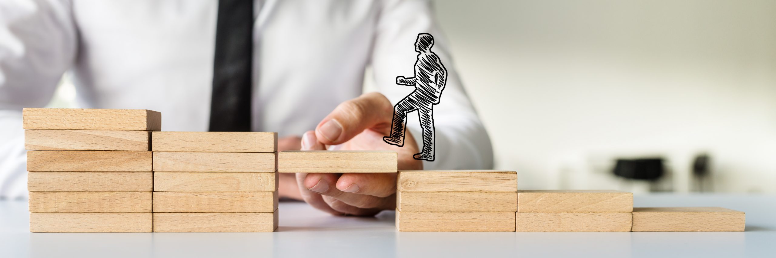 Hand drawn shape of a businessman walking up the wooden steps supported by hand, symbolizing the role of mid-level programs in the donor pipeline.