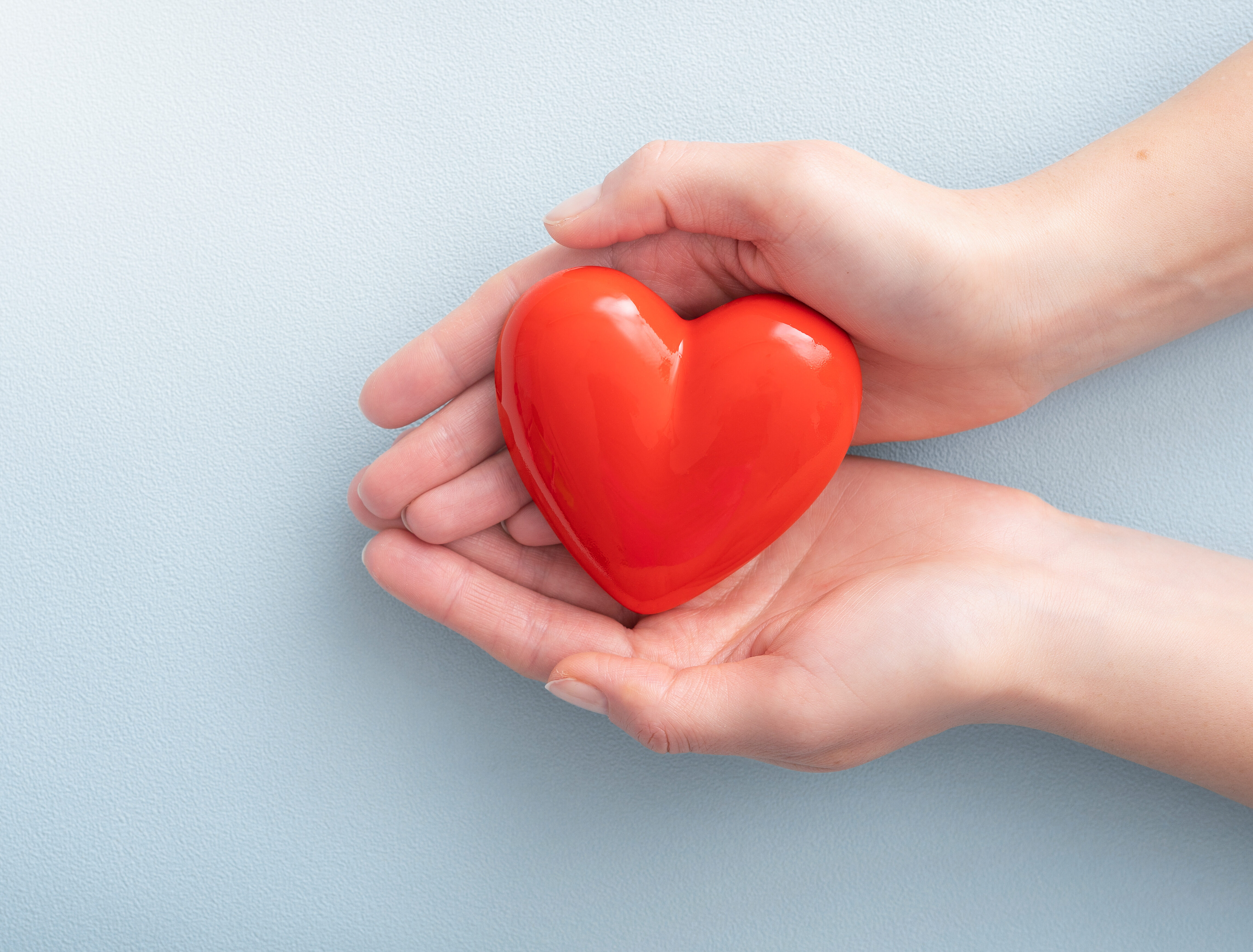 Hands are holding a red heart, symbolizing emotions in fundraising. [Let Your Heart Show]