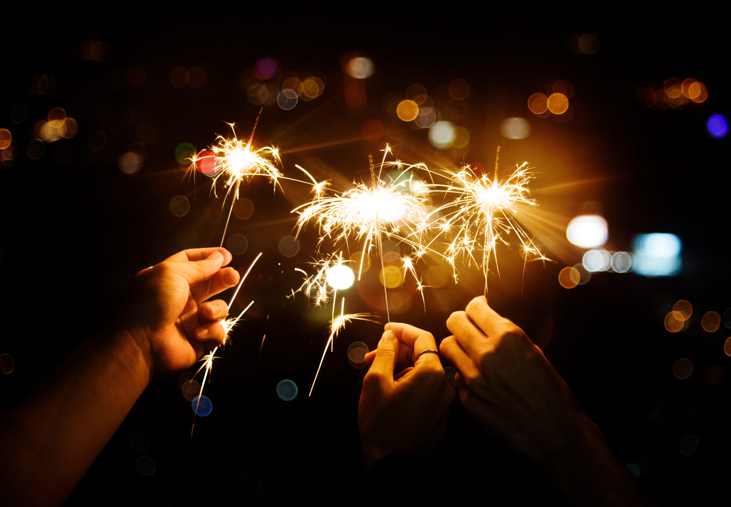 Hands holding sparklers [7 Wishes for Non-Profit Leaders in 2023]