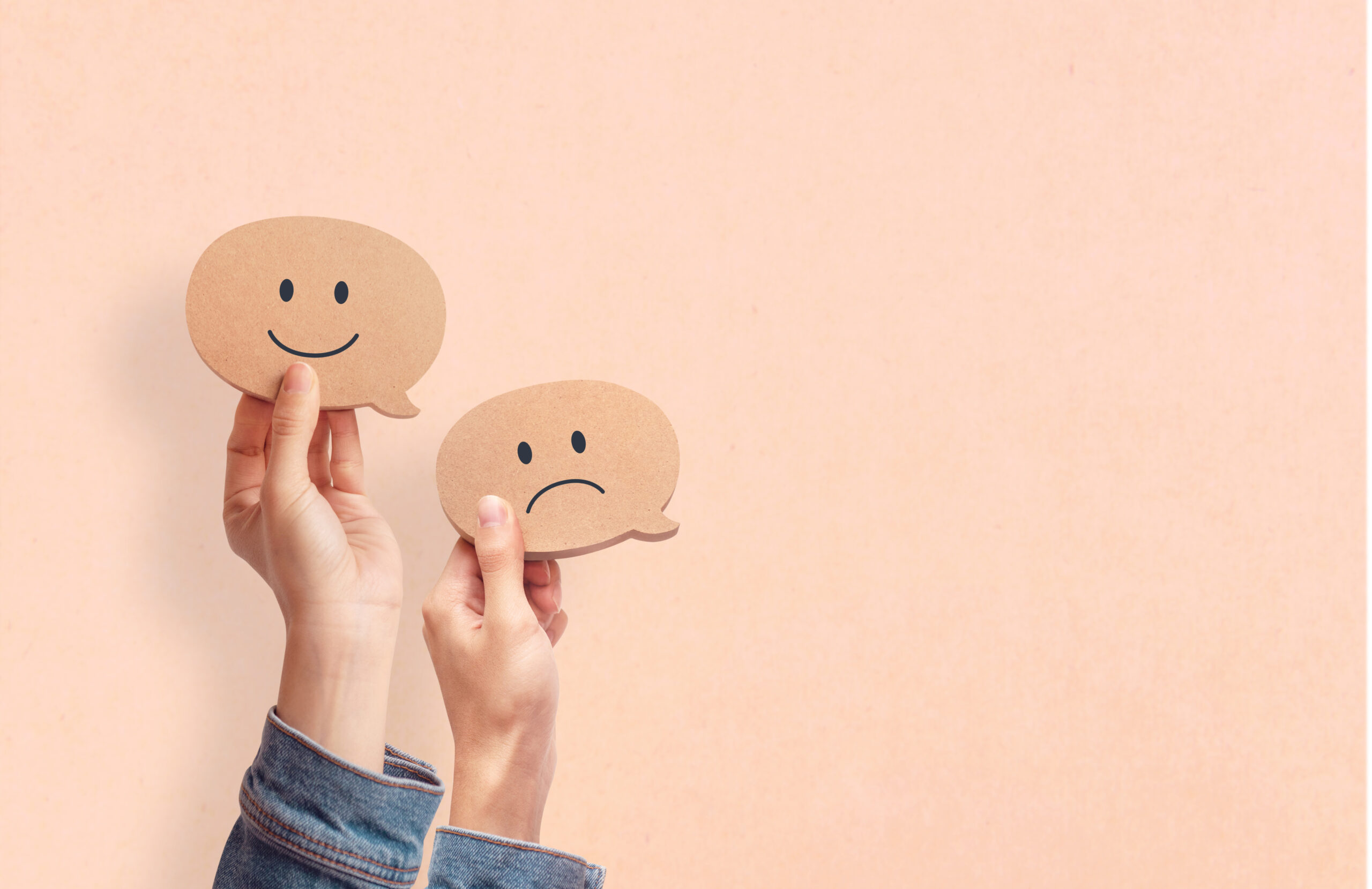 One hand holding a smiley face and the other holding a frowny face [Why Your Donor May Be Confused About Their Relationship With You]