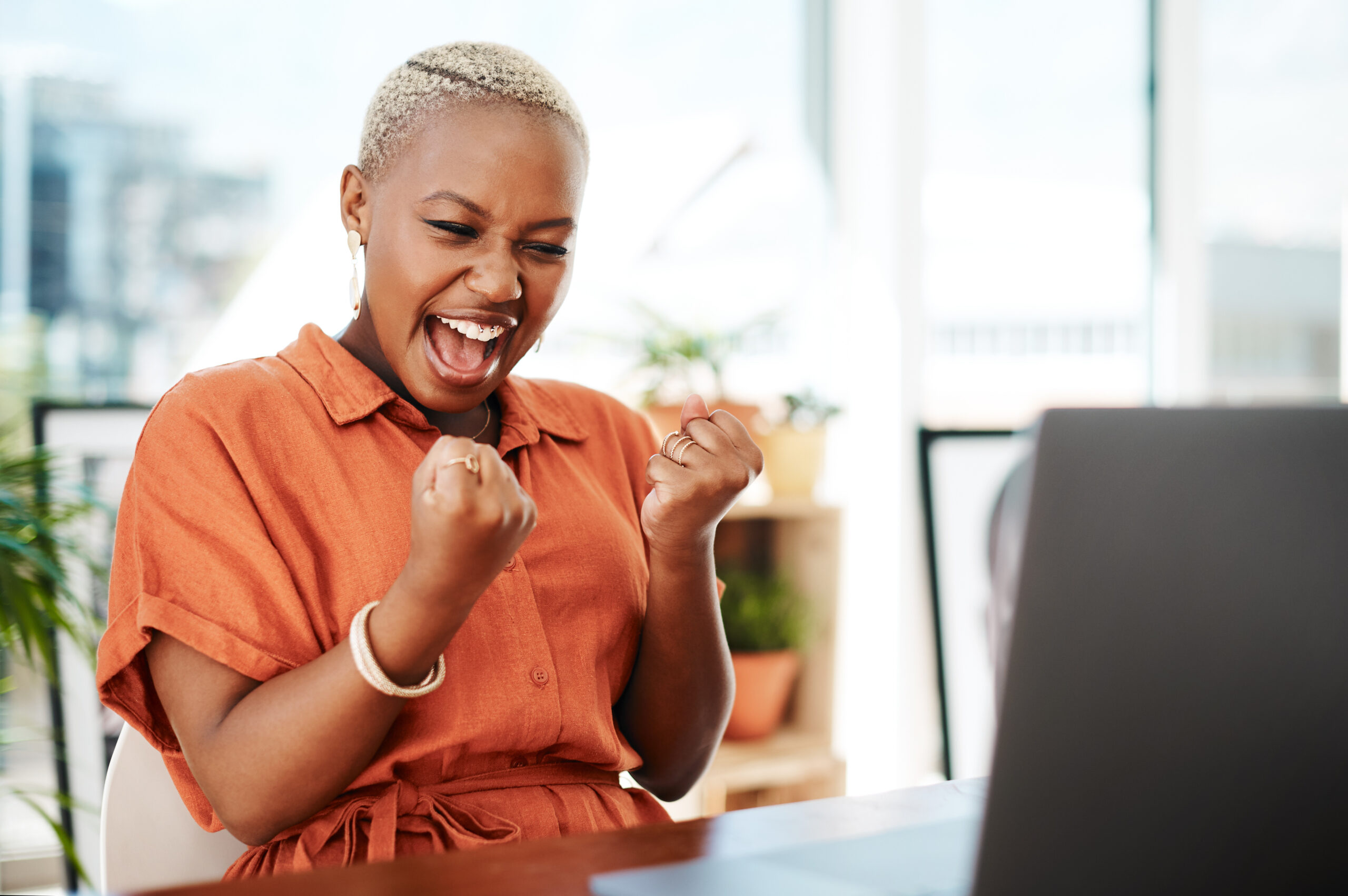 Black business woman celebrates success after making a compelling offer. [Big Gifts Come from Bold Offers]