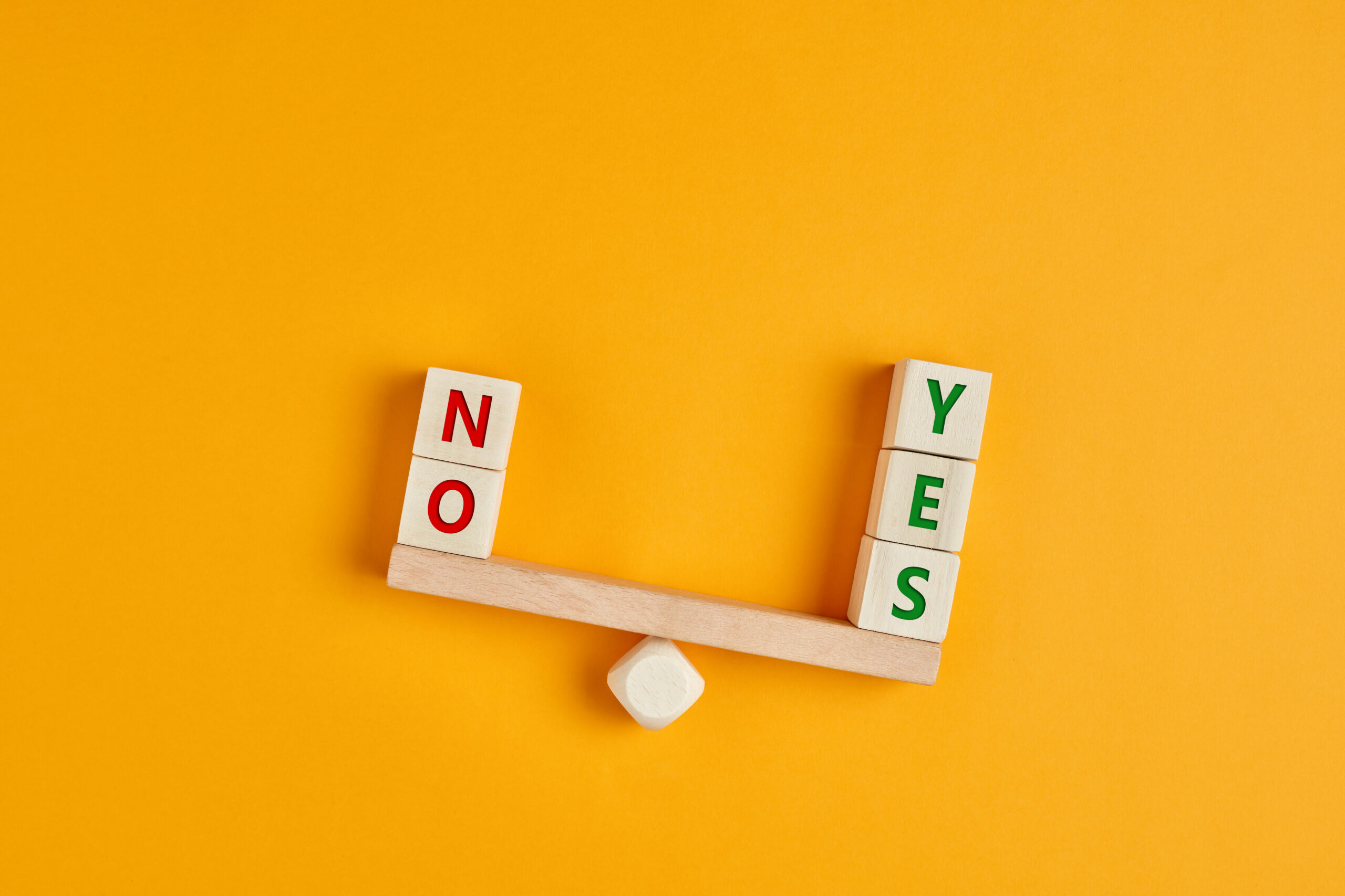 Yes and no inscription on wooden cubes on a seesaw with yes outweighs no. [What is the 'Yes'?]