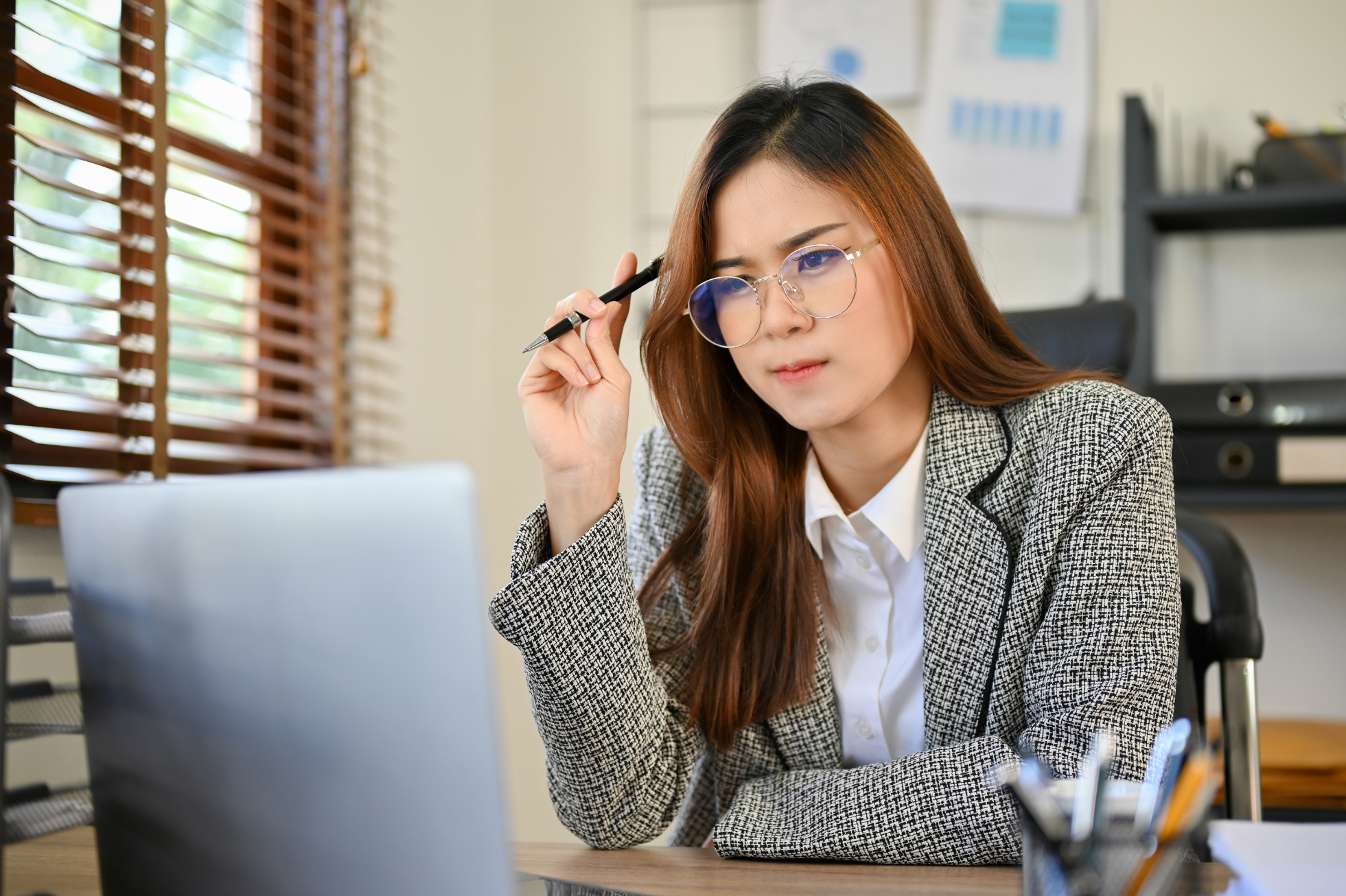 A fundraiser looks pensively at a laptop screen [Worried About Meeting Your Fundraising Goals This Year? Here's What to Focus On]