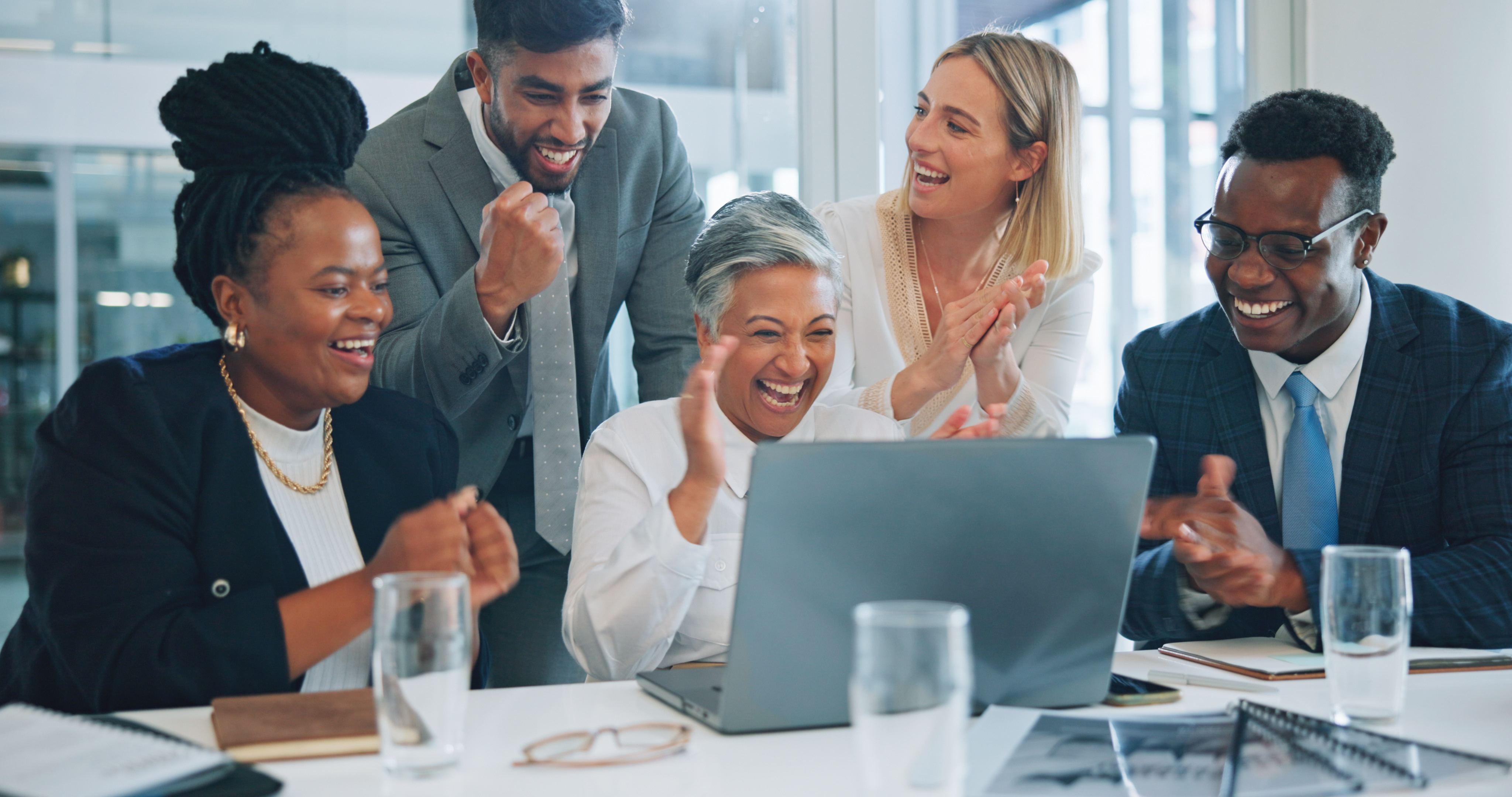 Fundraising team gathered around computer celebrating results. [How Are Your Major Gift Fundraising Results?]